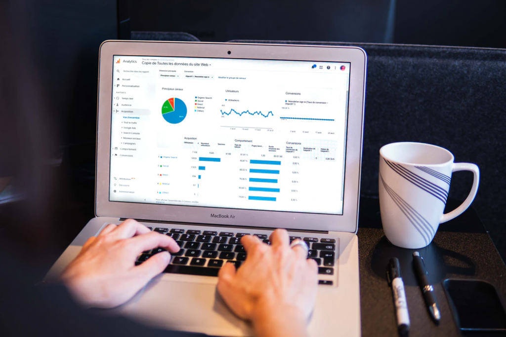 Someone working on a laptop showing analytical data.
